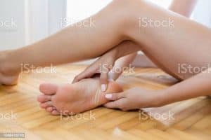 Woman massaging her aching foot